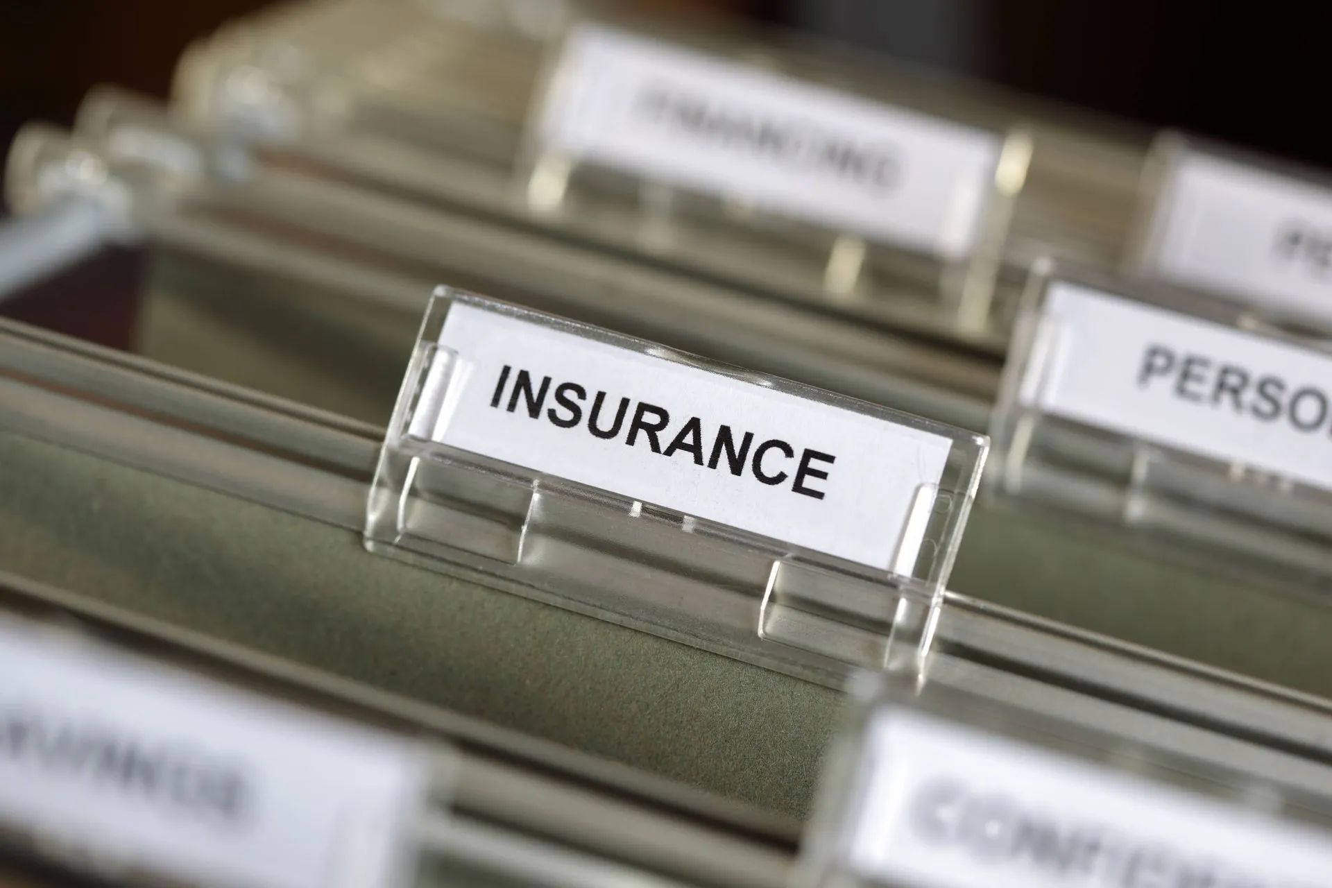 Close-up of a hanging file folder tab labeled 'Insurance'.