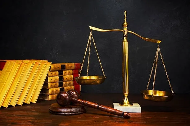 Scales of justice, a gavel, and books on a table.