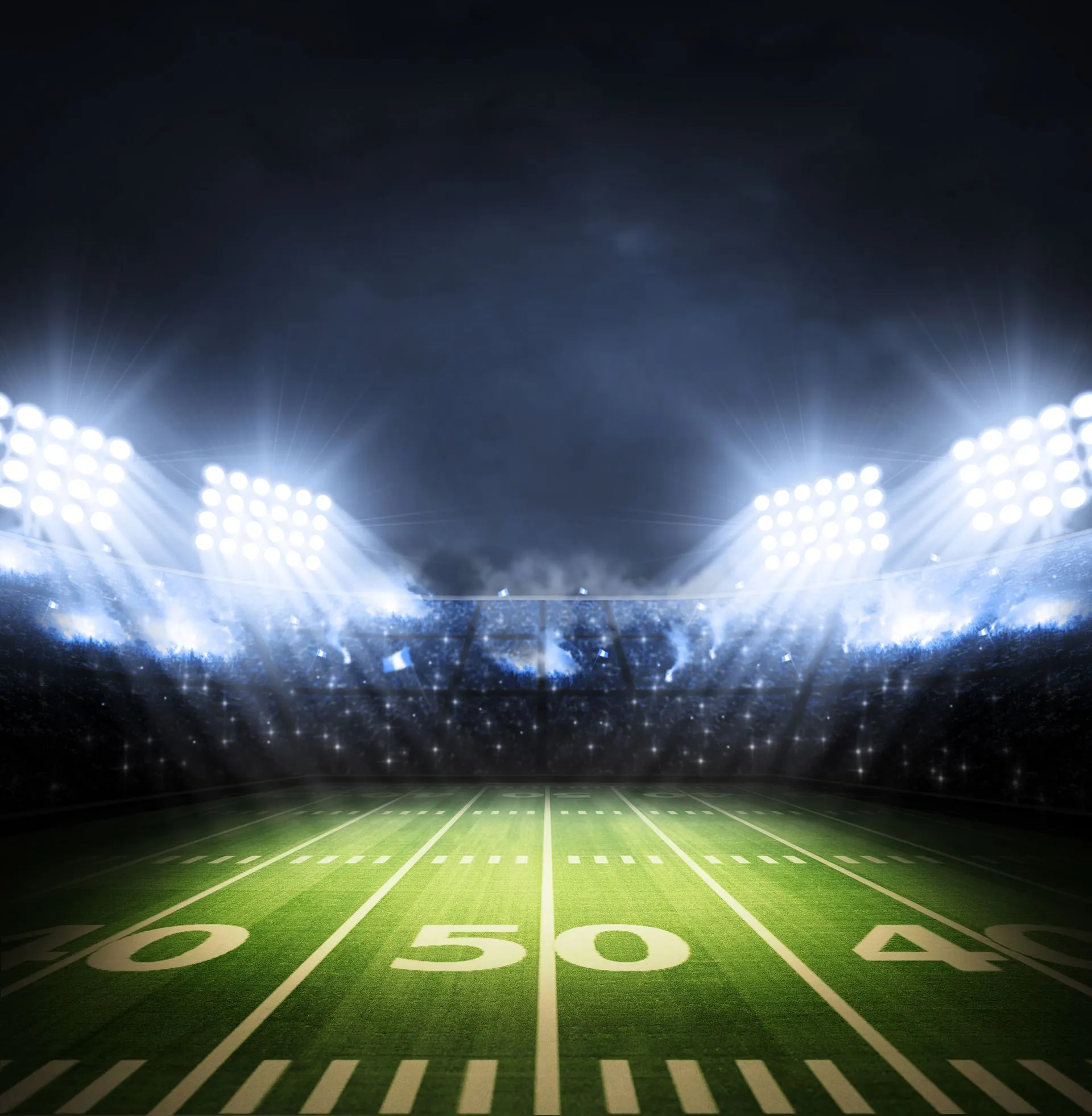 An empty American football stadium lit up at night.