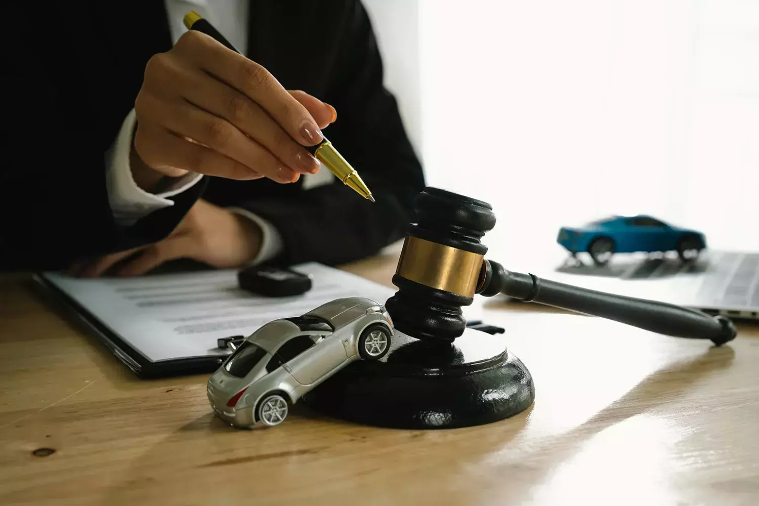 A lawyer uses a gavel near a toy car.