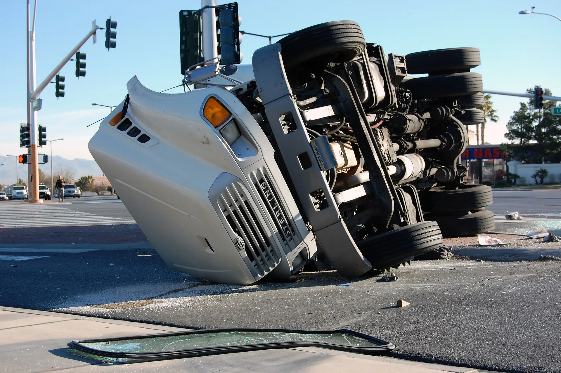 A 'Sterling' semi-truck overturned on a city street.