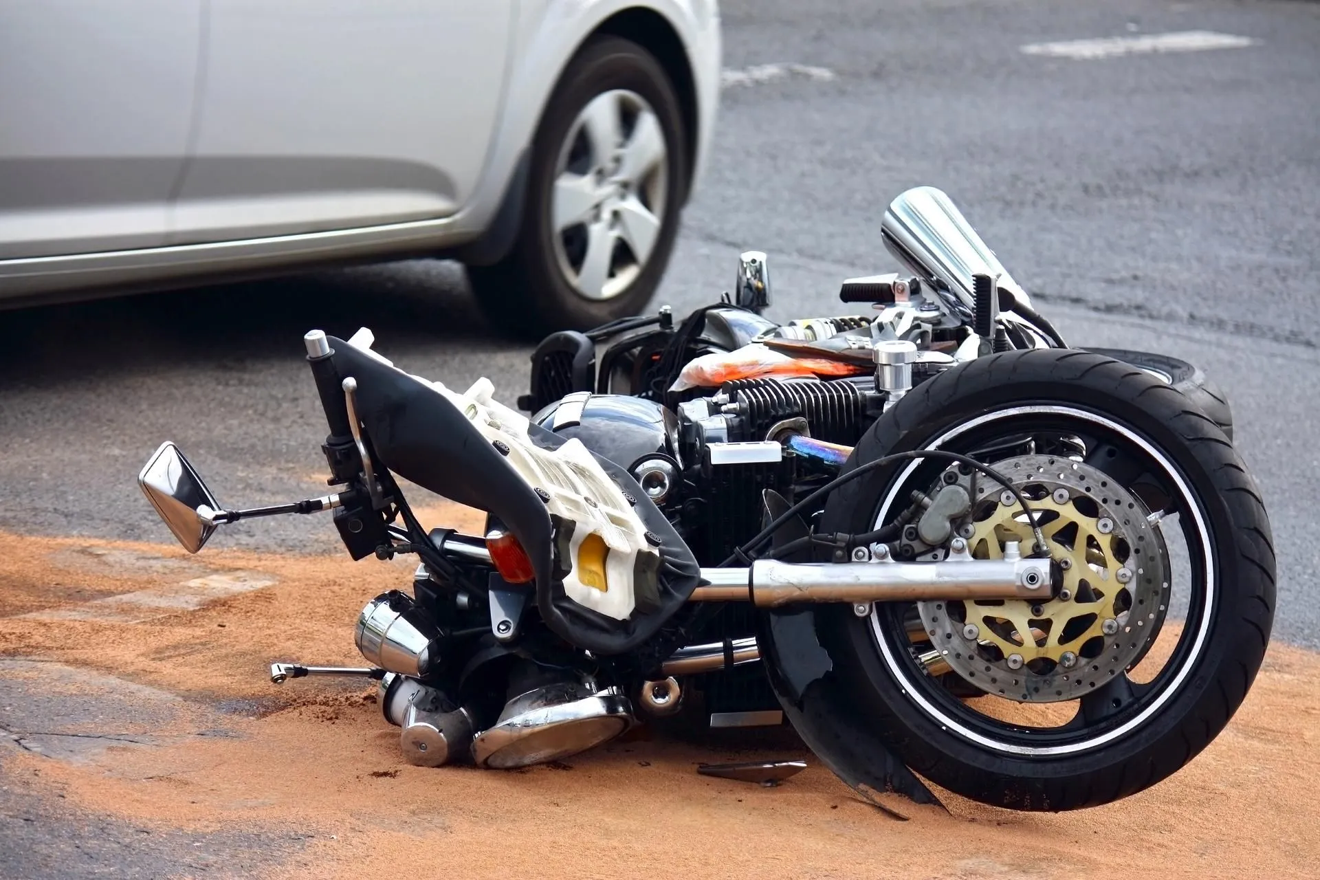 A heavily damaged motorcycle lying on the ground.