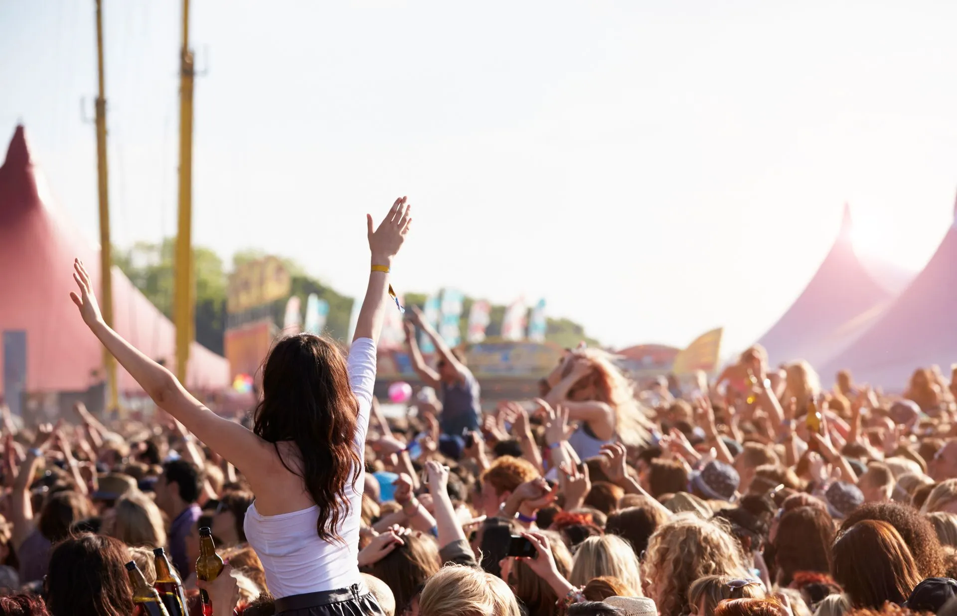 A large crowd enjoying a live music festival outdoors.