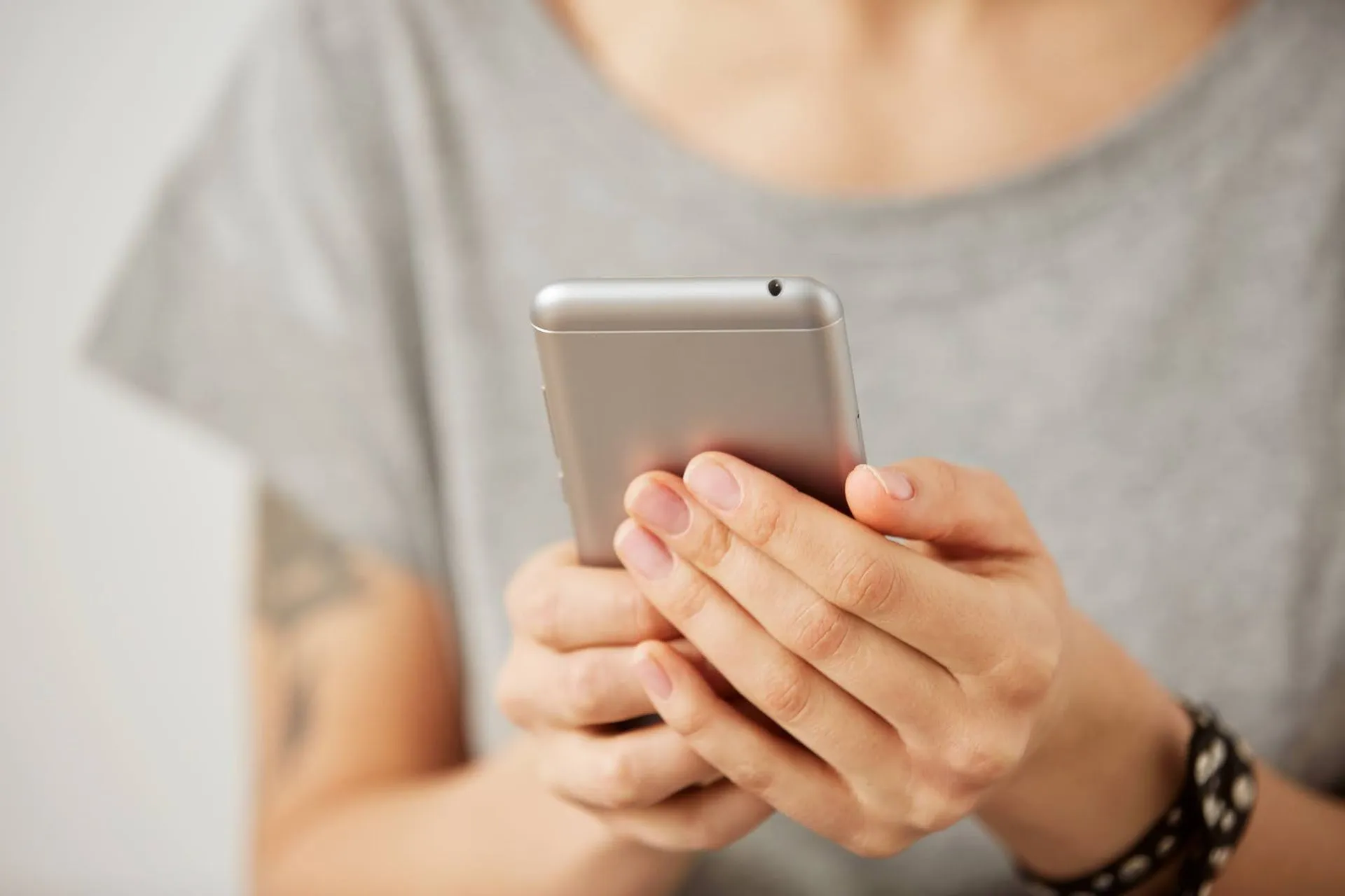 A person holding and looking at a smartphone.