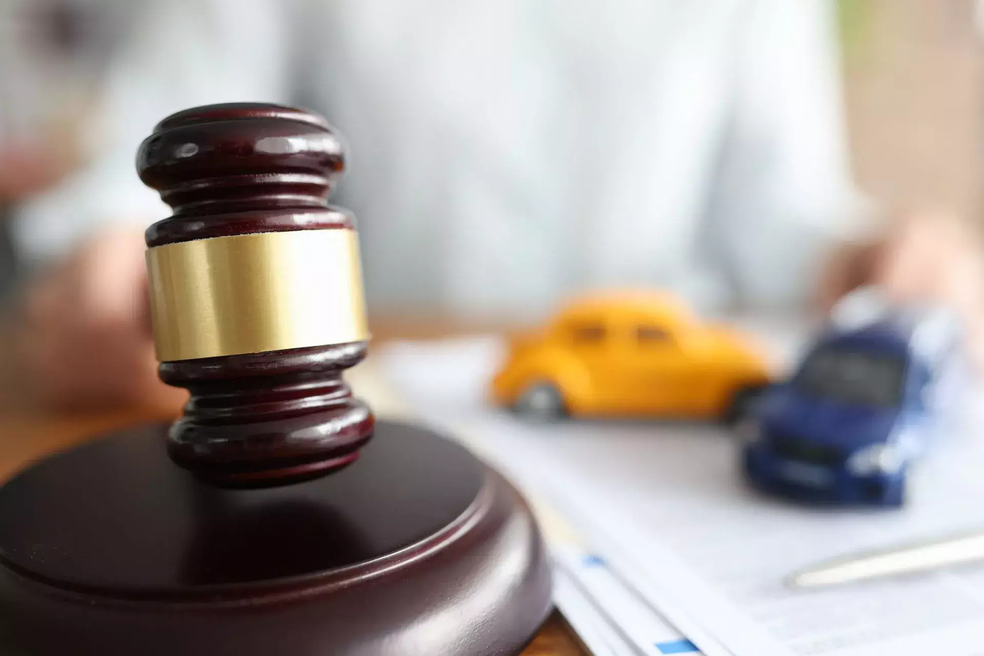 Judge’s gavel beside toy cars symbolizing a legal case involving a vehicle accident.