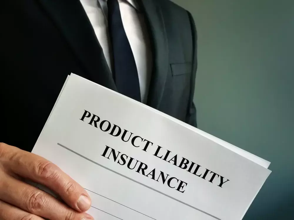 A person in a suit holding a document titled 'Product Liability Insurance'.