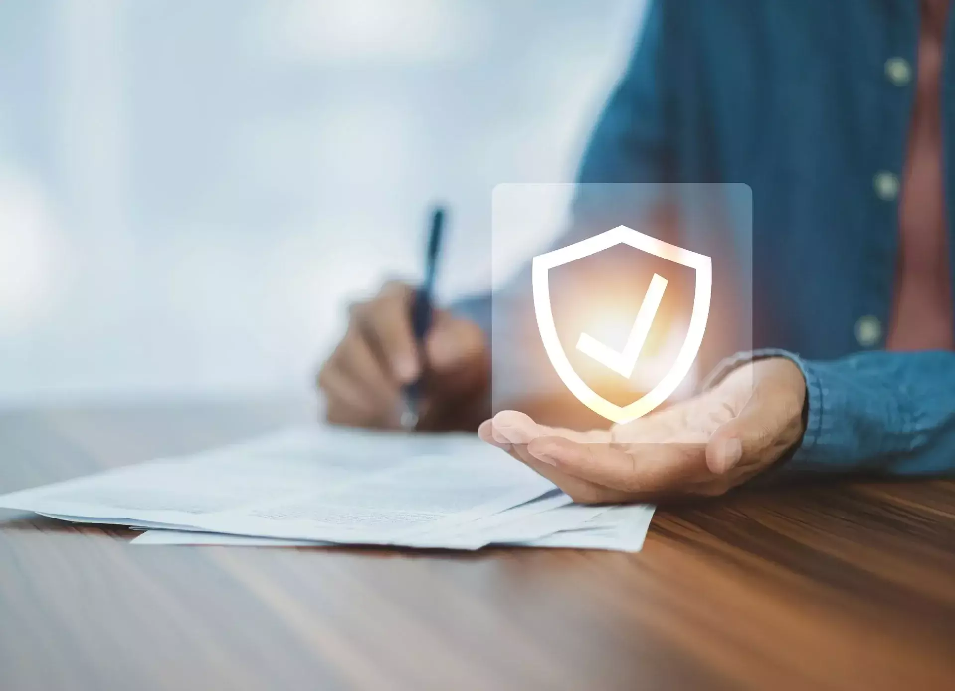 A person holding a digital shield icon with a checkmark.