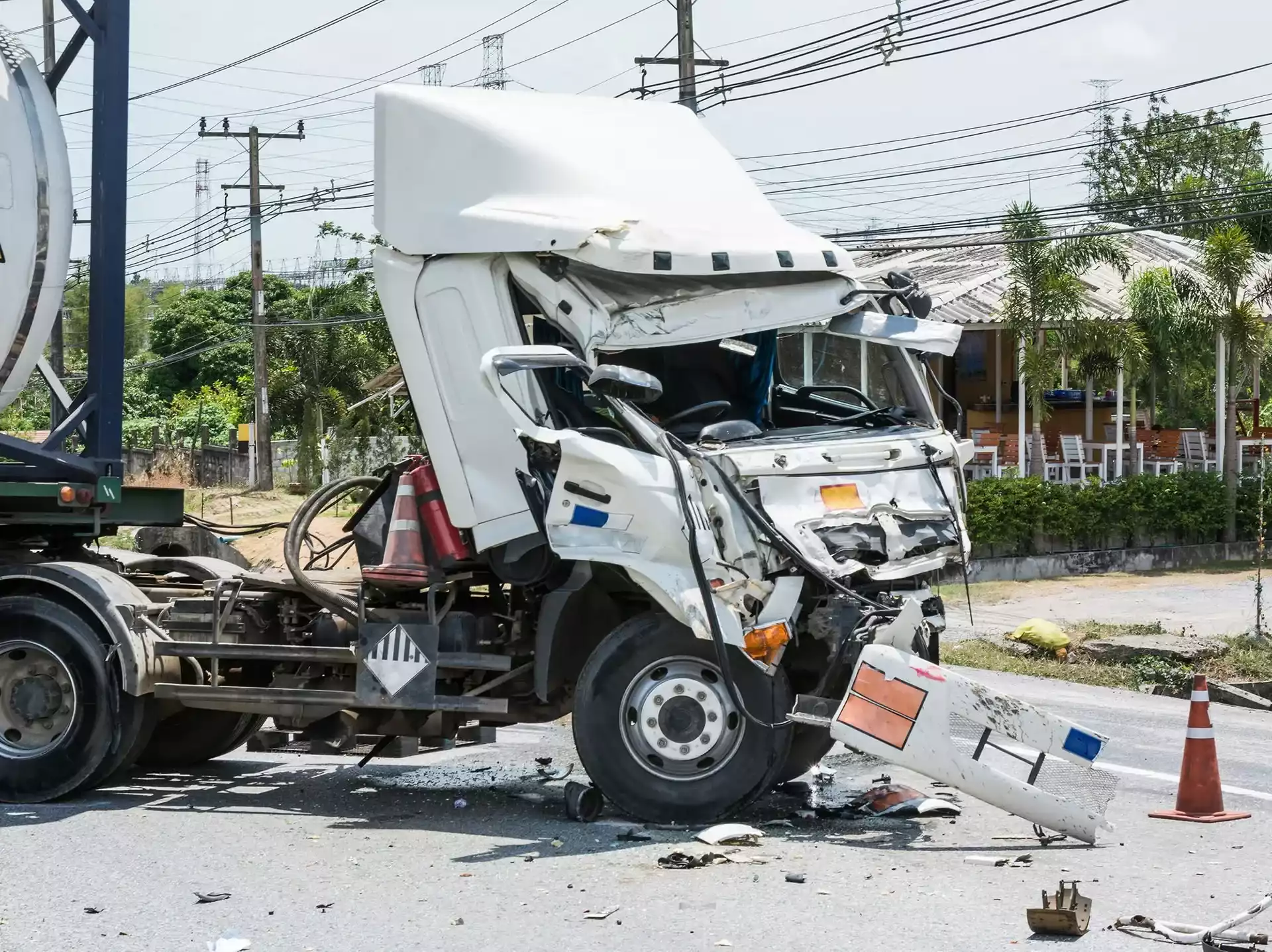 A severely damaged white semi-truck crashed on a road.