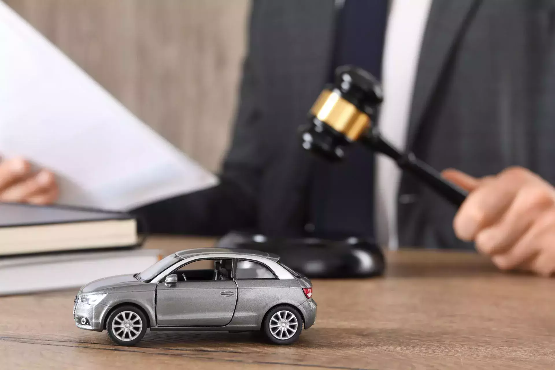 Accident attorney with document and gavel at wooden table.