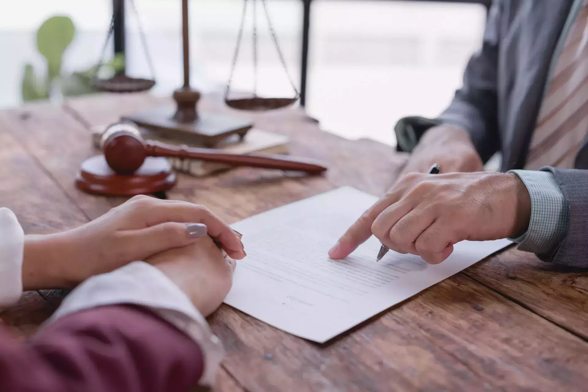 Un abogado especializado en lesiones personales revisando documentos legales con un cliente en un escritorio.