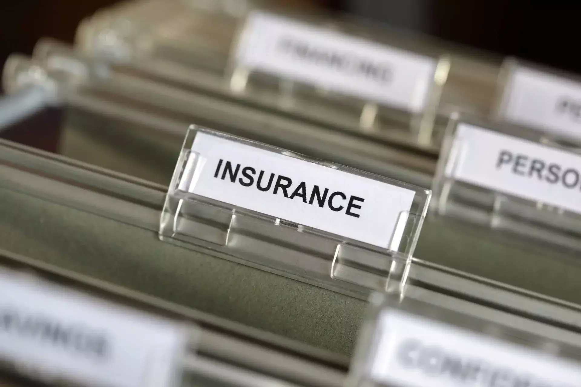Close-up of a hanging file folder tab labeled 'Insurance'.
