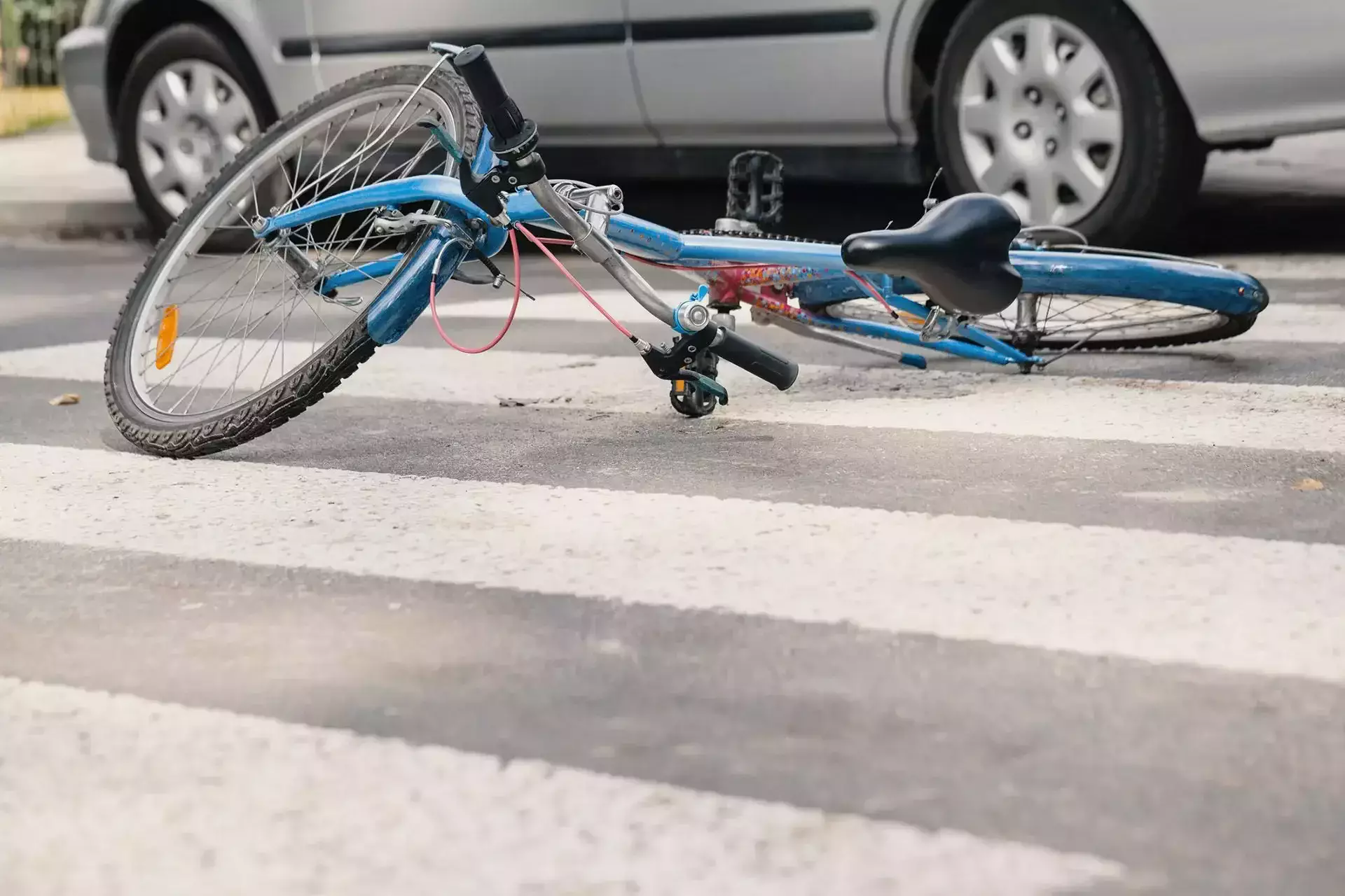 Bicycle lying on a pedestrian crossing near a vehicle after a traffic accident