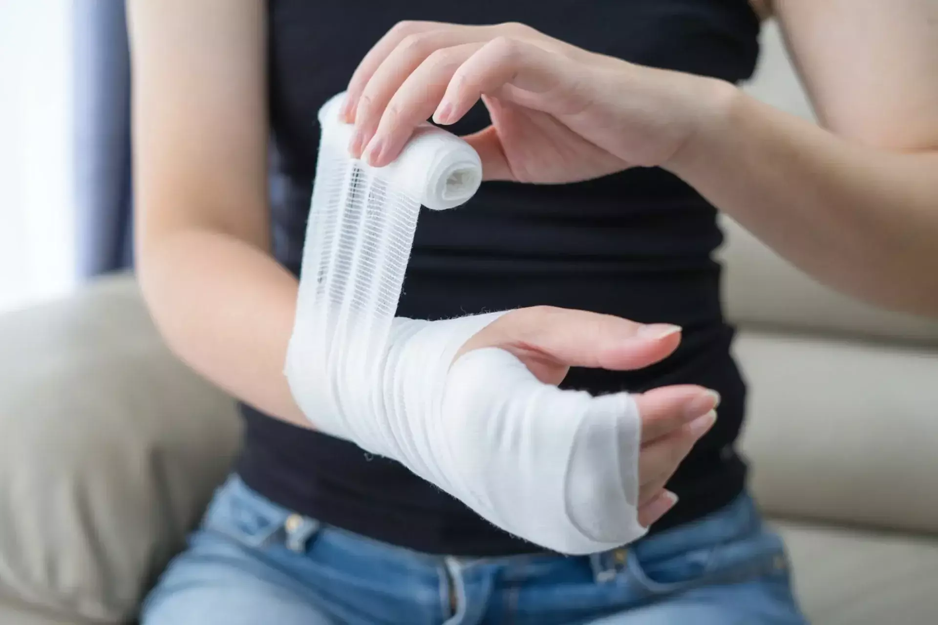 Person wrapping an injured hand and wrist with a medical bandage