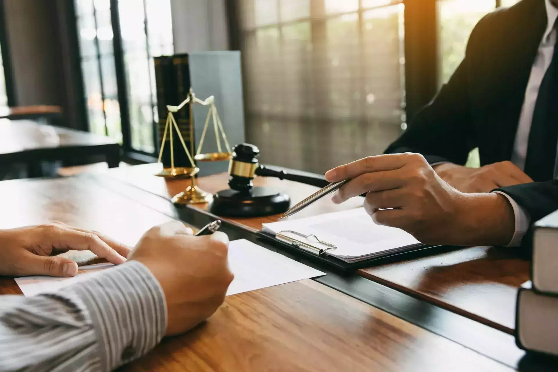 Attorney reviewing and discussing legal documents with a client during an office consultation.