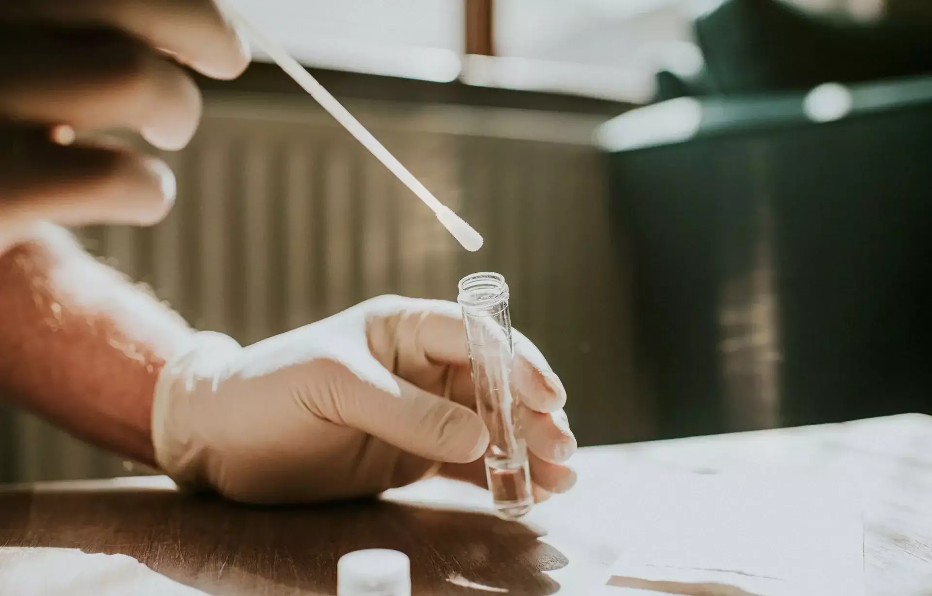 Laboratory technician collecting a sample with a swab and test tube
