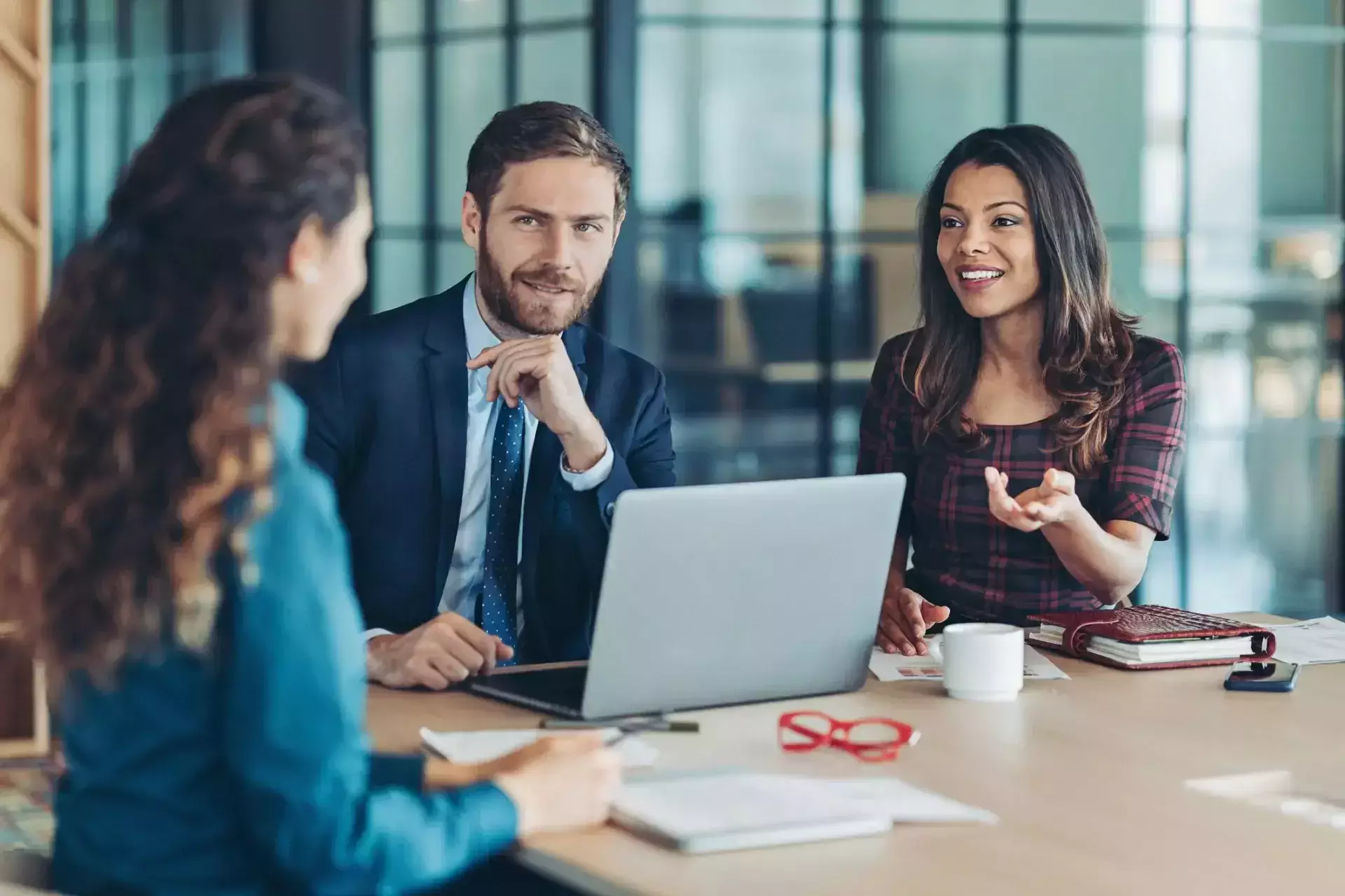 Business professionals discussing documents during a meeting in a modern office.
