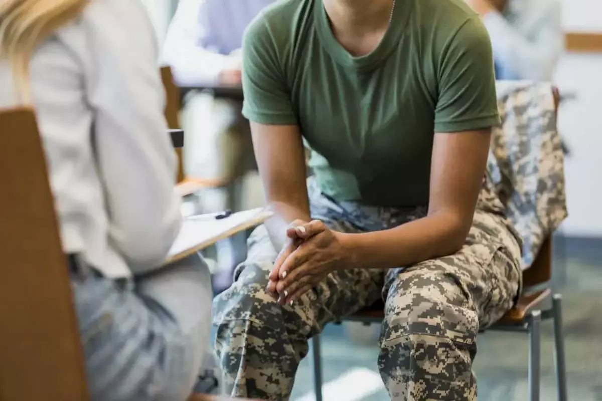 Miembro del servicio militar hablando con un profesional durante una sesión de consejería.