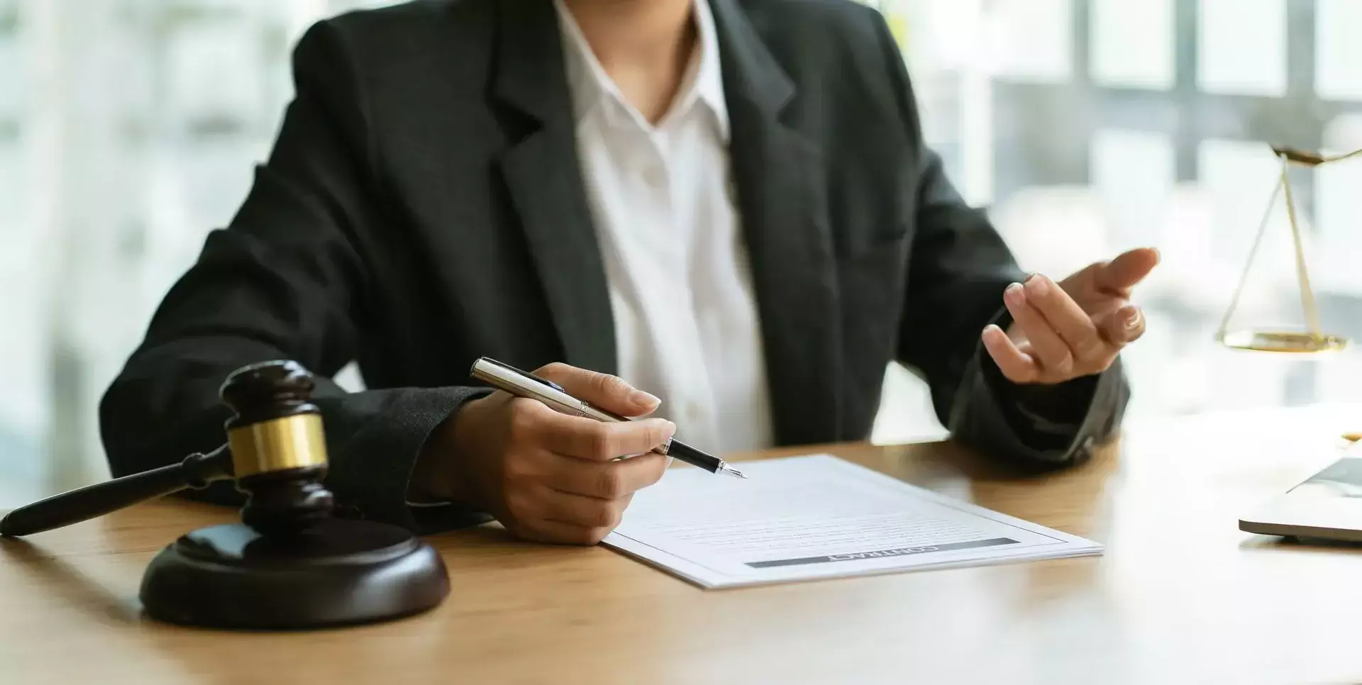 Lawyer reviewing legal documents at a desk with a judge’s gavel and scales of justice