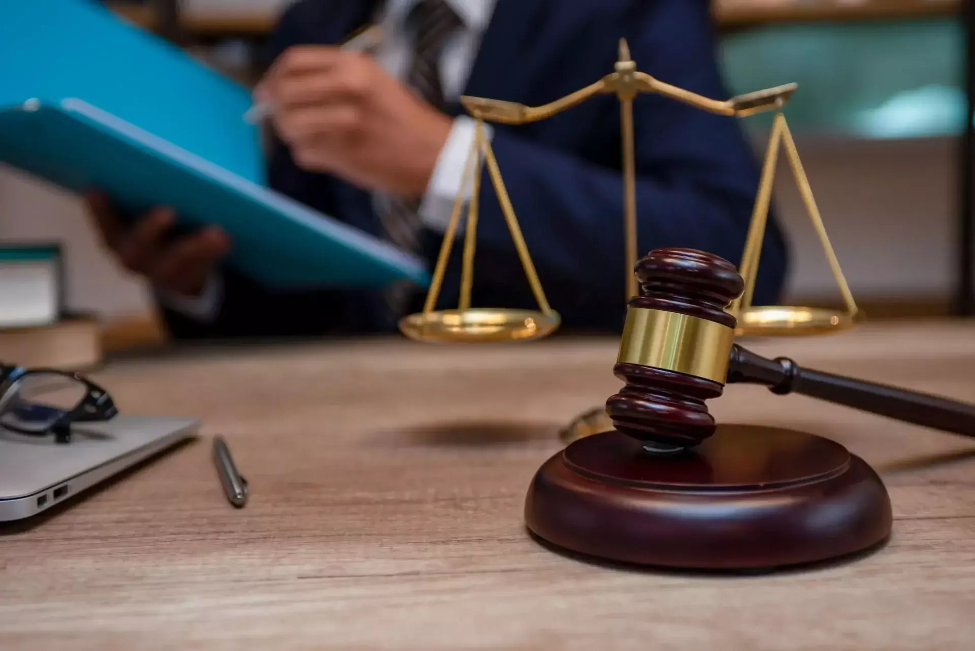 Lawyer reviewing legal documents with a judge’s gavel and scales of justice on the desk