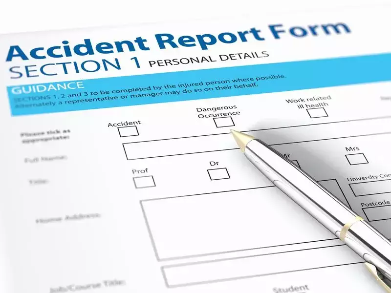 Accident report form for recording personal and incident details with a pen