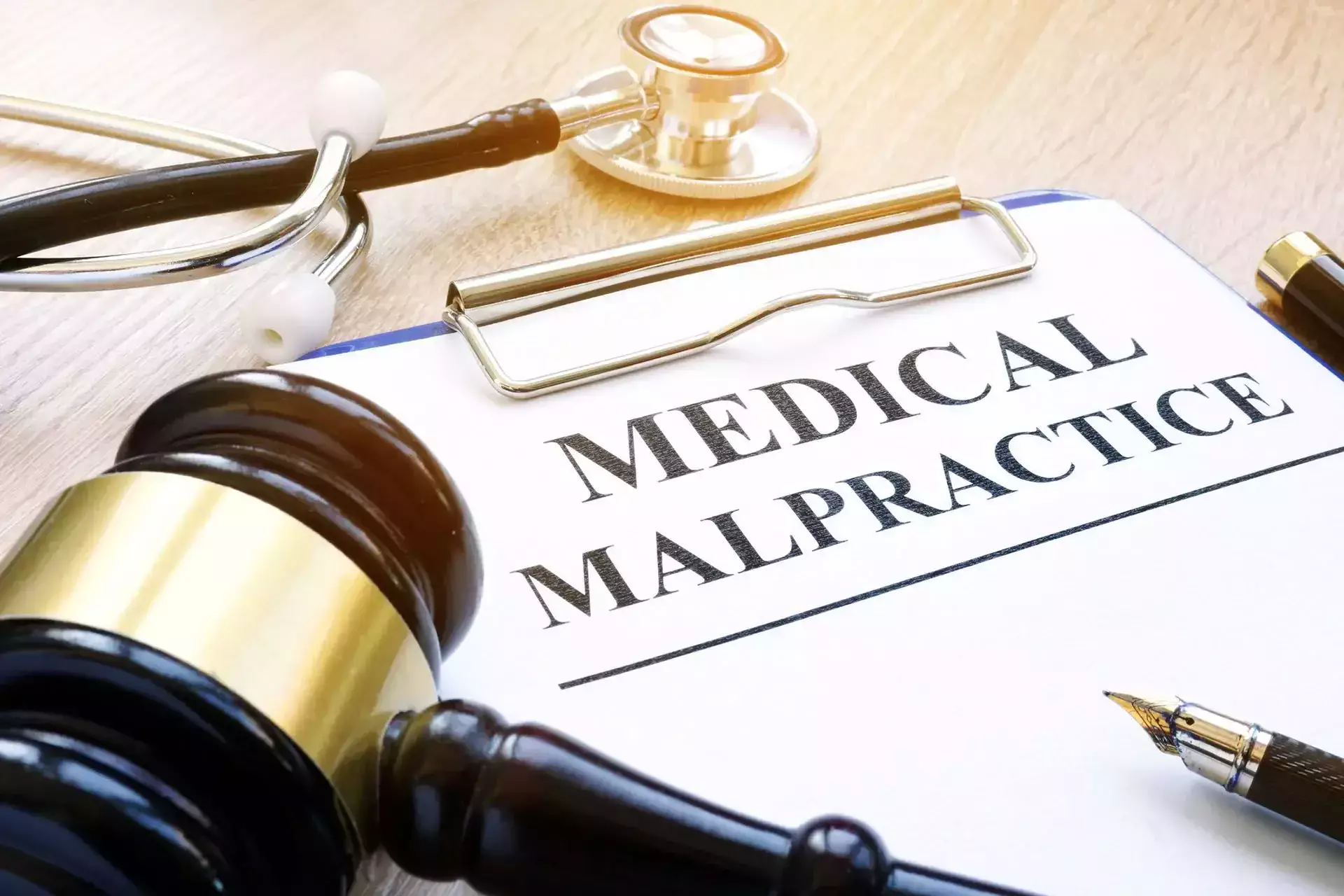 A clipboard with 'Medical Malpractice', a gavel, and a stethoscope.