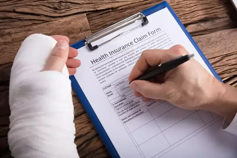 Injured person completing a health insurance claim form
