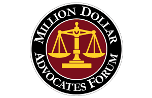 Million Dollar Advocates Forum. Black ring with white text surrounding a burgundy and gold scales of justice.