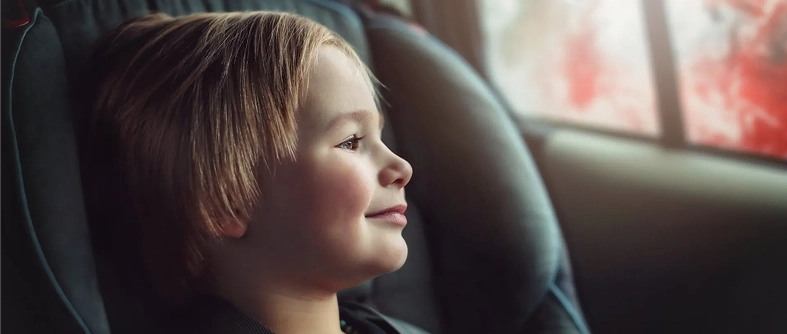 Young child sitting safely in a car seat inside a vehicle.
